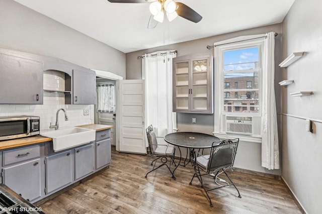 kitchen featuring backsplash, sink, gray cabinets, and hardwood / wood-style flooring