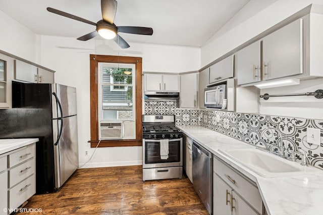 kitchen featuring backsplash, cooling unit, appliances with stainless steel finishes, gray cabinetry, and dark hardwood / wood-style flooring