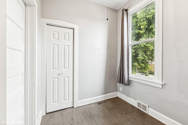 spare room featuring hardwood / wood-style flooring and a healthy amount of sunlight