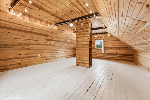 additional living space with hardwood / wood-style floors, wood walls, and wood ceiling