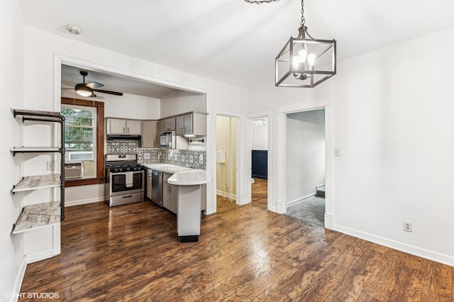 kitchen with decorative backsplash, hanging light fixtures, gray cabinetry, stainless steel appliances, and dark hardwood / wood-style flooring