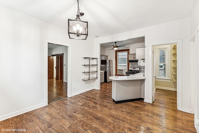 kitchen with decorative light fixtures, dark hardwood / wood-style floors, decorative backsplash, appliances with stainless steel finishes, and white cabinets