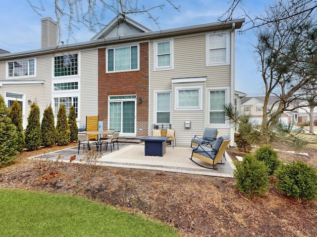 rear view of property featuring a patio and a fire pit