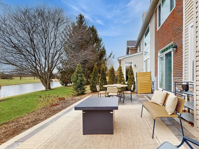 view of patio featuring a water view and an outdoor living space with a fire pit