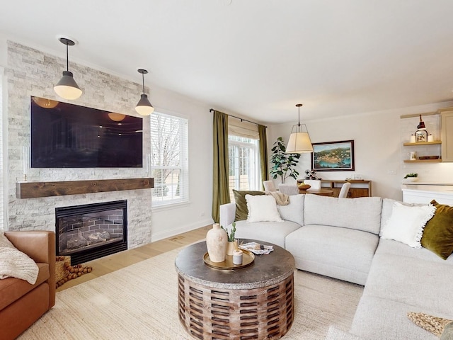 living room featuring a stone fireplace and light wood-type flooring