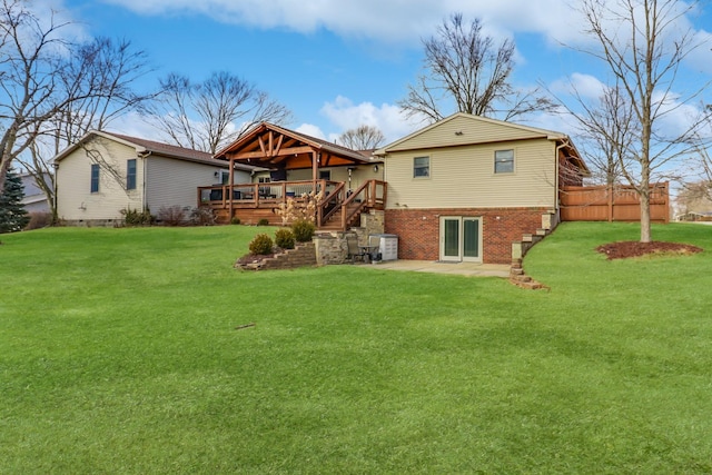 rear view of house with a deck, a yard, and a patio