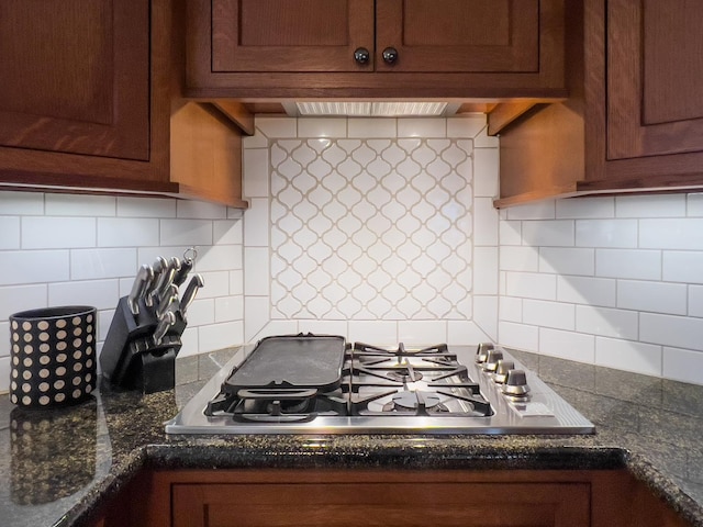 kitchen featuring tasteful backsplash, dark stone counters, and stainless steel gas cooktop