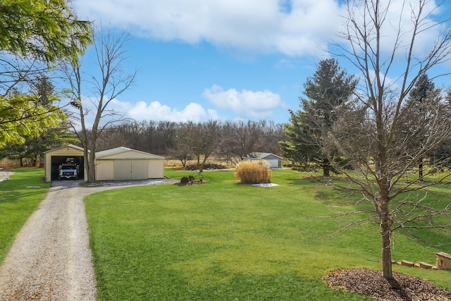 view of yard with a garage and an outbuilding