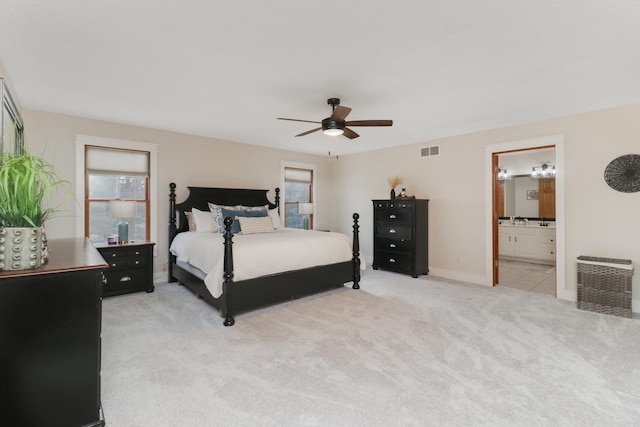 bedroom featuring ceiling fan, light carpet, and ensuite bath