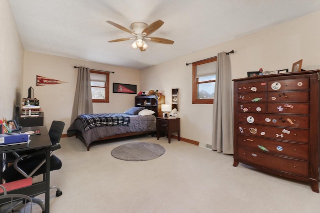 carpeted bedroom featuring ceiling fan and a textured ceiling