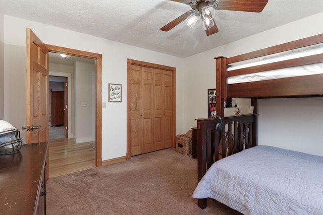 carpeted bedroom featuring a textured ceiling and ceiling fan