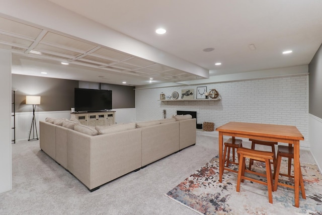 carpeted living room with a brick fireplace and brick wall