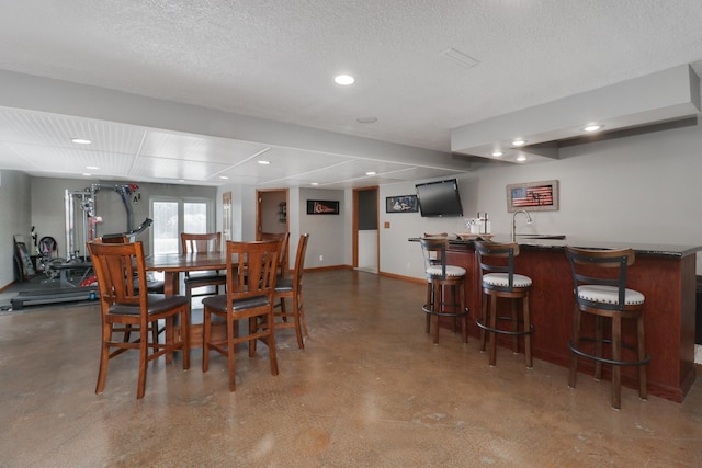 dining room with indoor wet bar and a textured ceiling