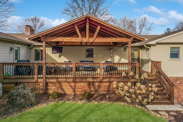 rear view of house featuring a deck and a lawn