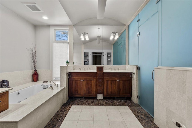 bathroom with vanity, tile patterned flooring, vaulted ceiling, and independent shower and bath