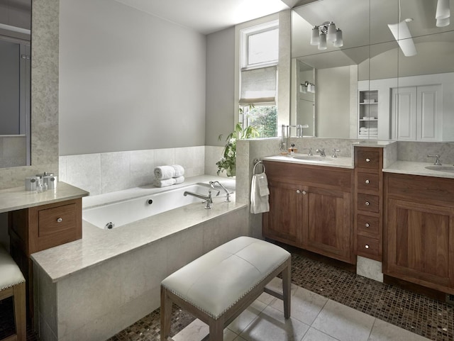 bathroom with vanity, backsplash, tile patterned floors, and tiled bath