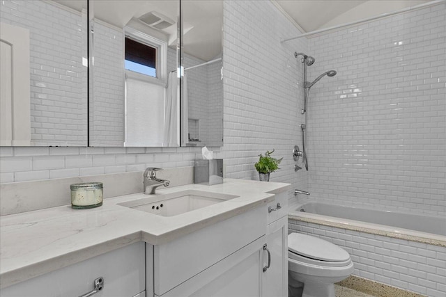 full bathroom with vanity, tiled shower / bath, decorative backsplash, and toilet