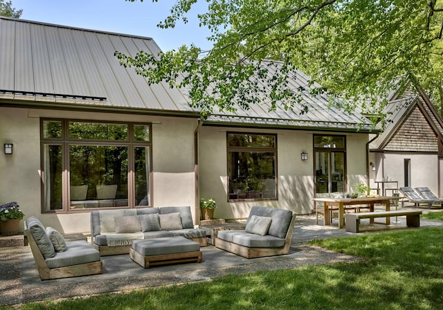 back of property featuring an outdoor hangout area, a patio area, and a lawn