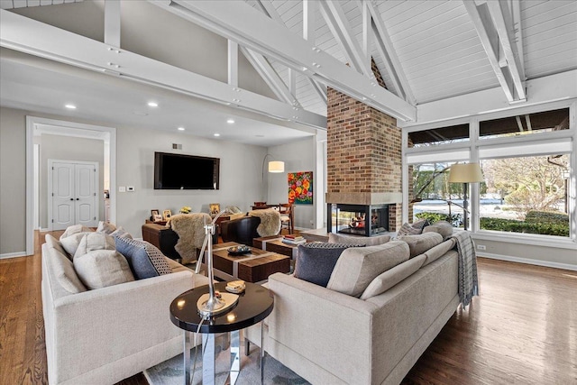 living room featuring hardwood / wood-style flooring, beam ceiling, high vaulted ceiling, and a brick fireplace