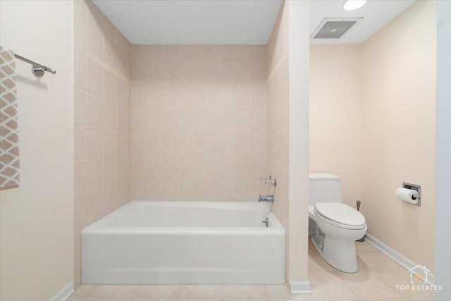 bathroom with tiled shower / bath, tile patterned floors, and toilet