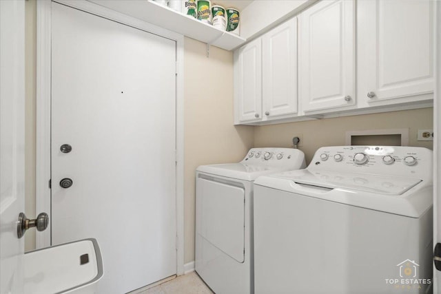 washroom featuring cabinets, separate washer and dryer, and light tile patterned floors