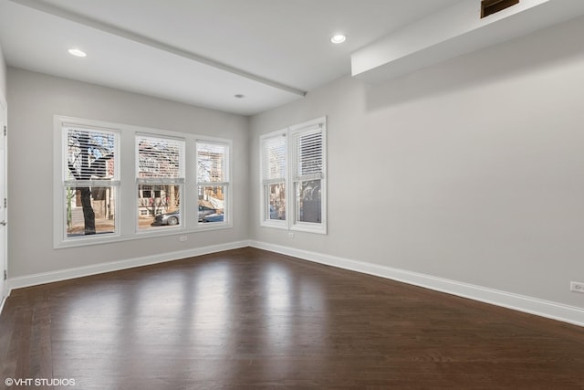 unfurnished room featuring a healthy amount of sunlight and dark hardwood / wood-style flooring