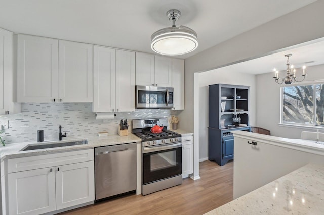 kitchen with white cabinetry, sink, tasteful backsplash, and appliances with stainless steel finishes