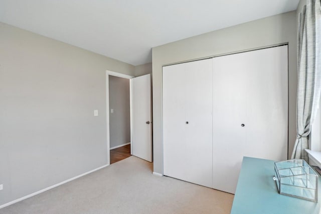 unfurnished bedroom featuring light colored carpet and a closet