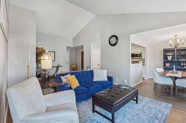 living room with wood-type flooring, a chandelier, and high vaulted ceiling