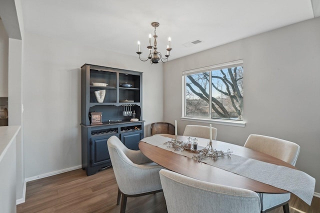 dining area featuring dark hardwood / wood-style flooring and a notable chandelier