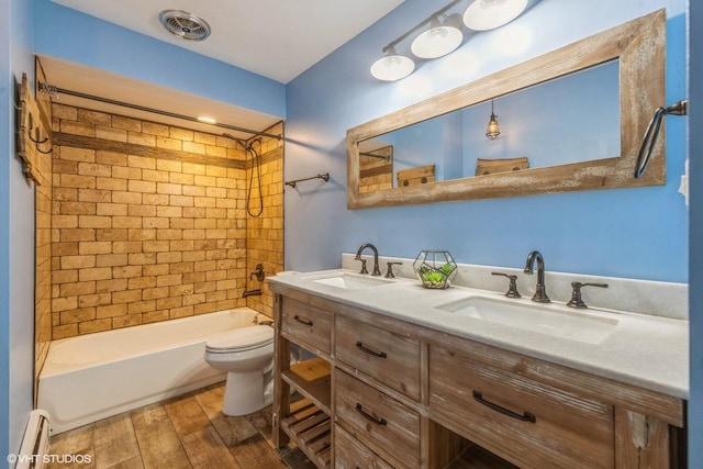 full bathroom with toilet, vanity, tiled shower / bath combo, hardwood / wood-style flooring, and a baseboard heating unit