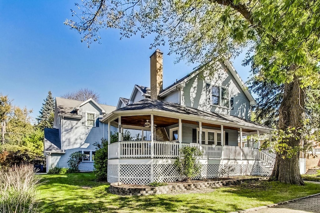 rear view of property featuring a porch and a lawn