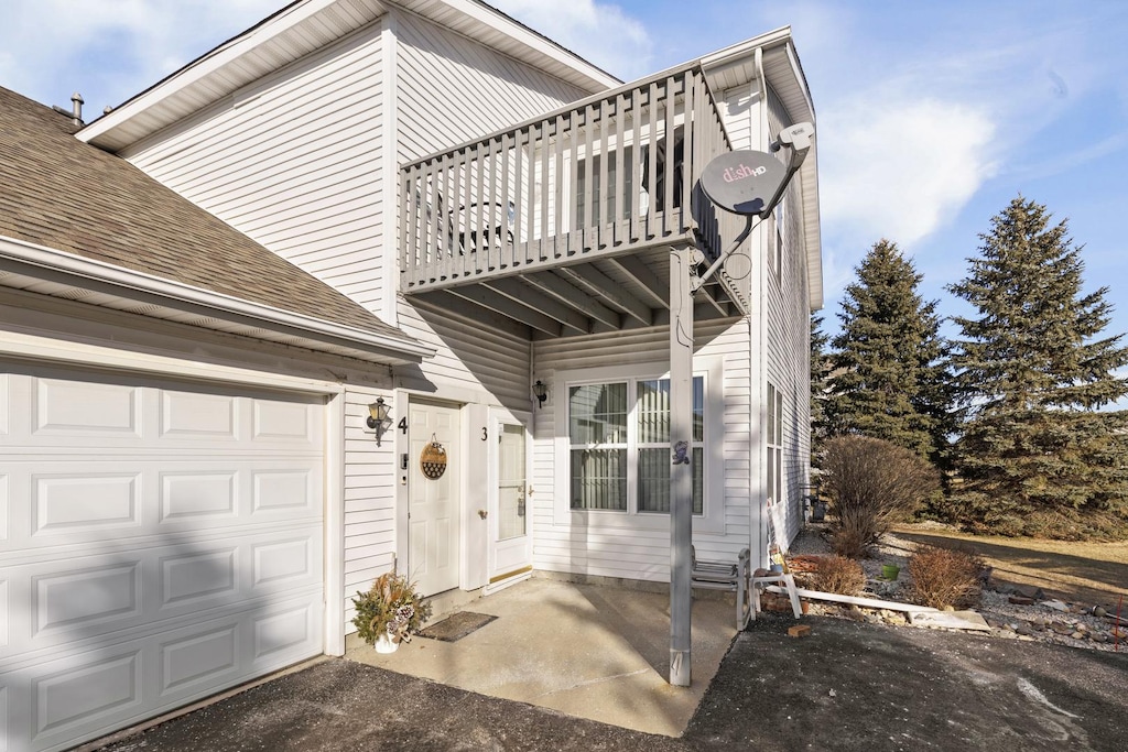 exterior space featuring a garage and a balcony