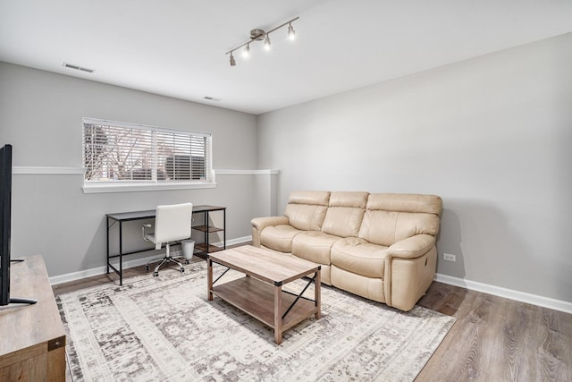 living room with hardwood / wood-style flooring and track lighting