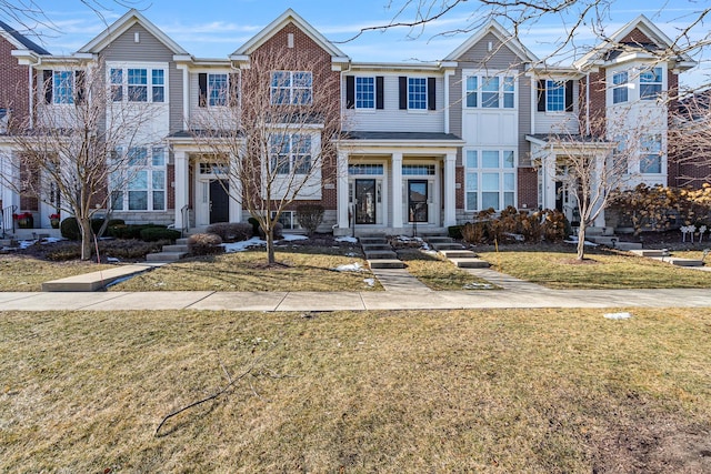 townhome / multi-family property featuring a front lawn