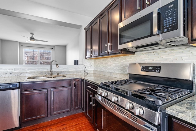 kitchen with light stone counters, sink, tasteful backsplash, and appliances with stainless steel finishes