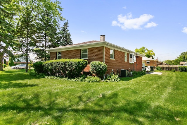 view of side of home with a lawn and cooling unit