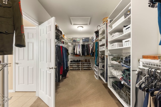 walk in closet with light tile patterned floors