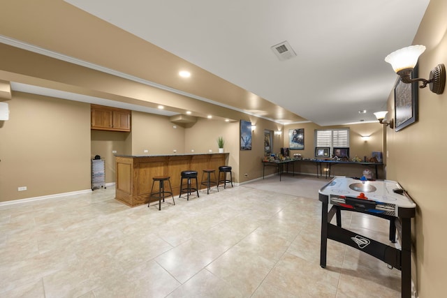 playroom featuring bar area and light tile patterned floors