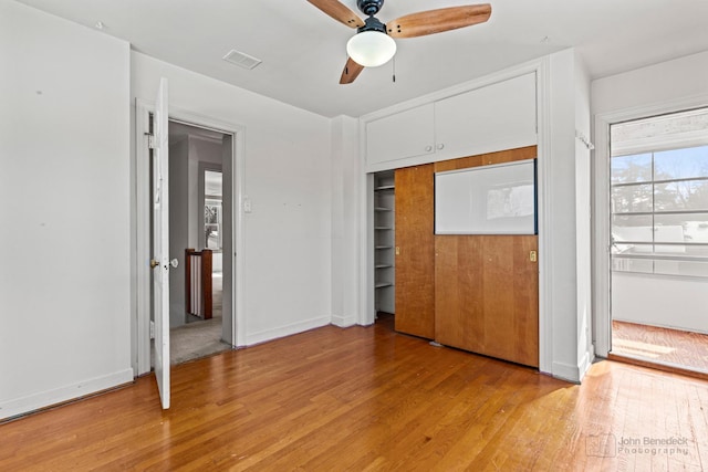 unfurnished bedroom with light hardwood / wood-style floors, a closet, and ceiling fan