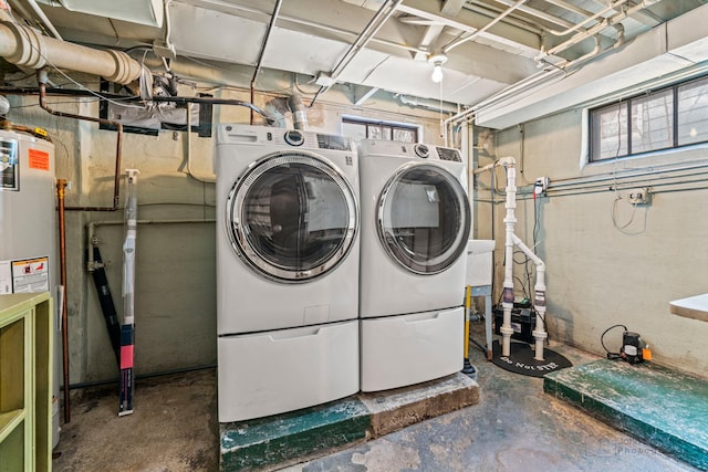 washroom with washing machine and dryer and water heater