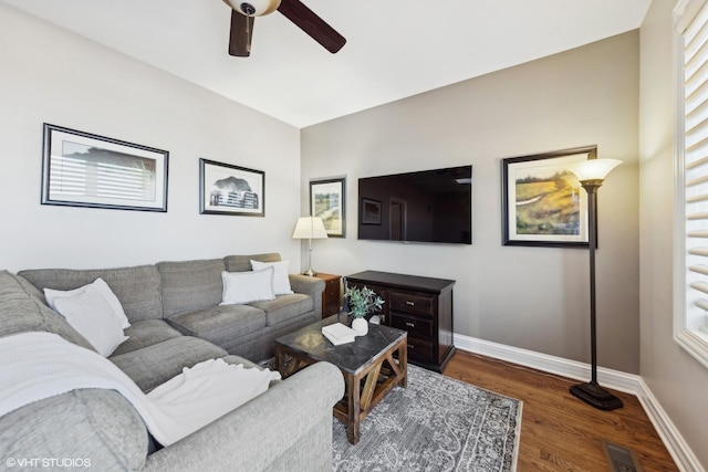 living room featuring dark wood-type flooring and ceiling fan