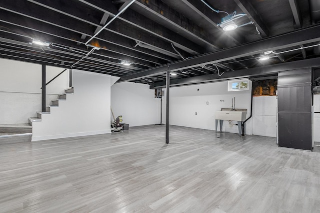 basement with wood-type flooring and sink