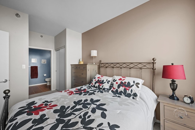 bedroom featuring ensuite bath, vaulted ceiling, and a closet