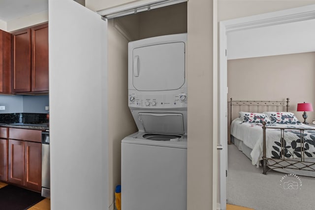 clothes washing area with stacked washer / dryer