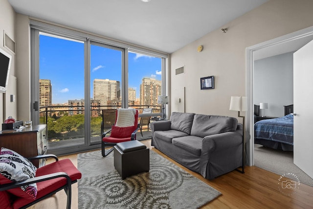 living room featuring hardwood / wood-style flooring and a wall of windows