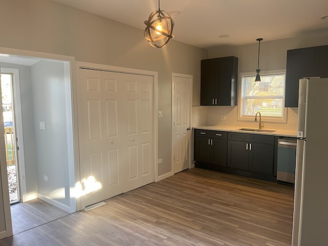 kitchen featuring hanging light fixtures, a healthy amount of sunlight, appliances with stainless steel finishes, and sink