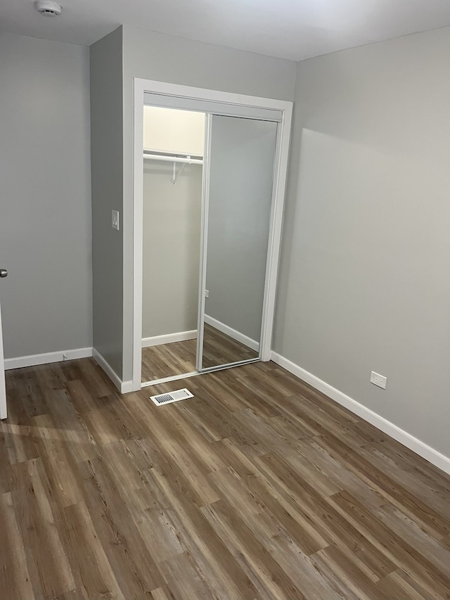 unfurnished bedroom featuring a closet and wood-type flooring