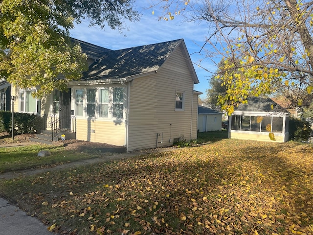 view of property exterior with a sunroom and a yard