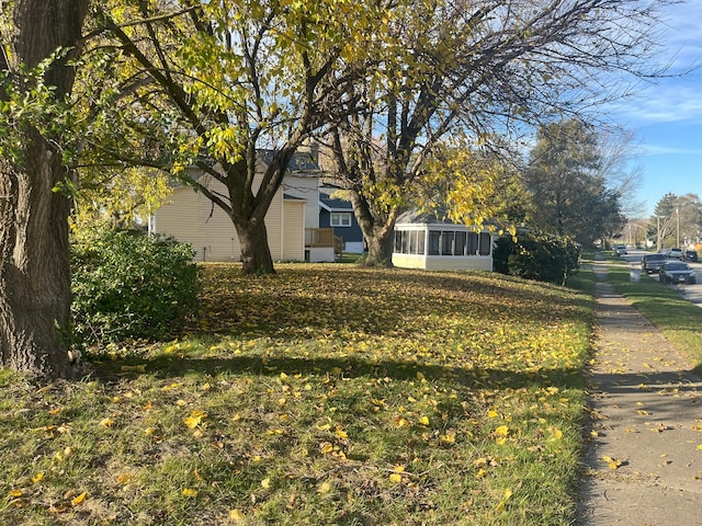 exterior space featuring a sunroom and a lawn